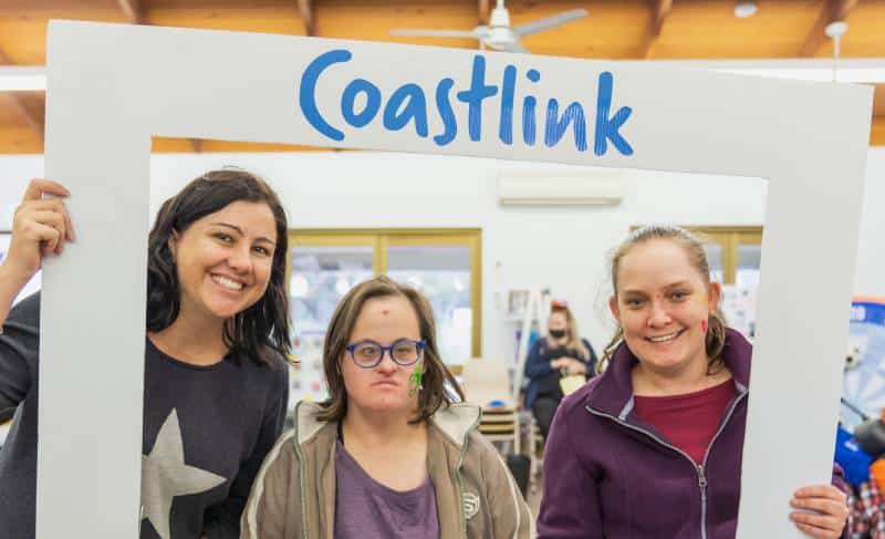Group having photo with the Coastlink Disability Banner