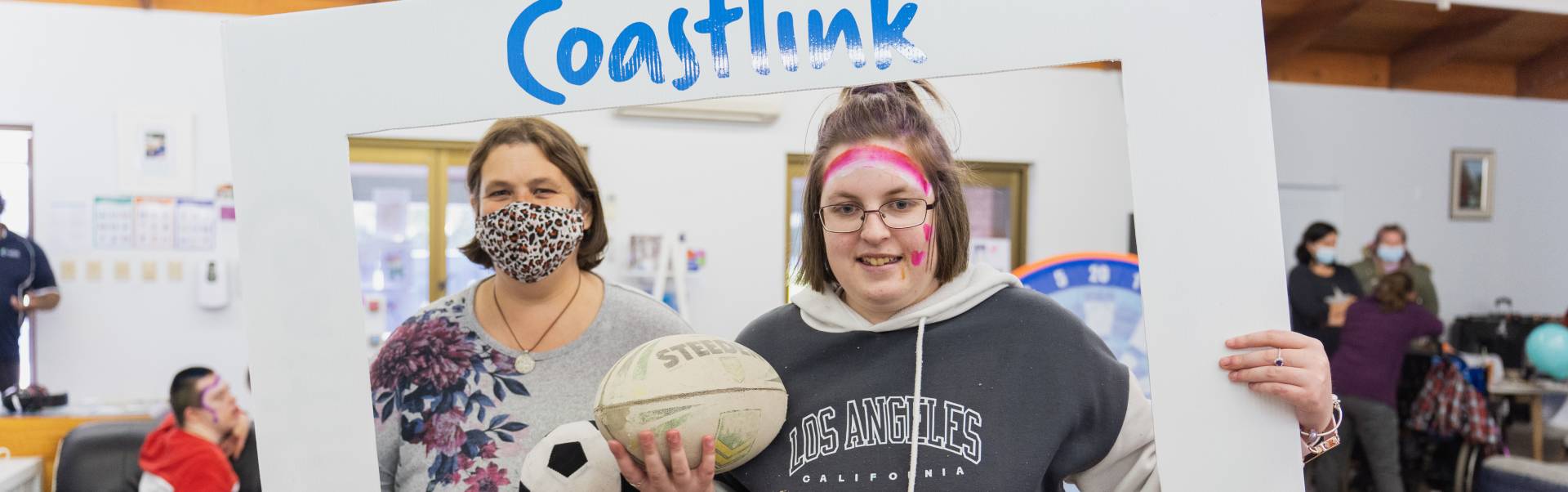 Coastlink carer and friend posing with a Disability Banner