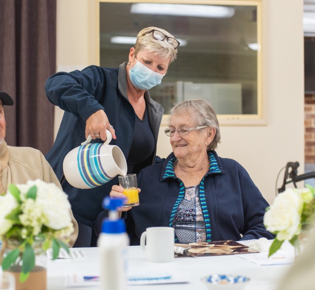 Coastlink carer serving drinks to an elderly couple