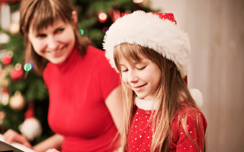 A mother and daughter in a Santa hat