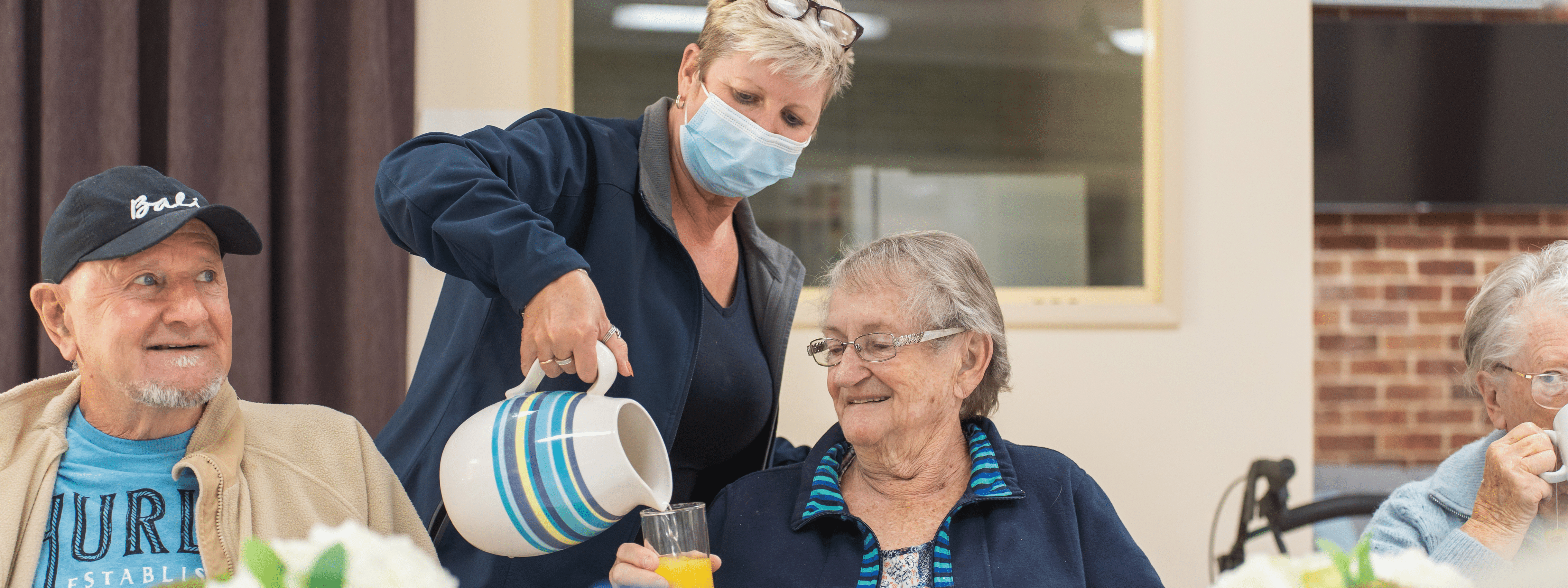 A Coastlink team member serves juice to an Aged Care client